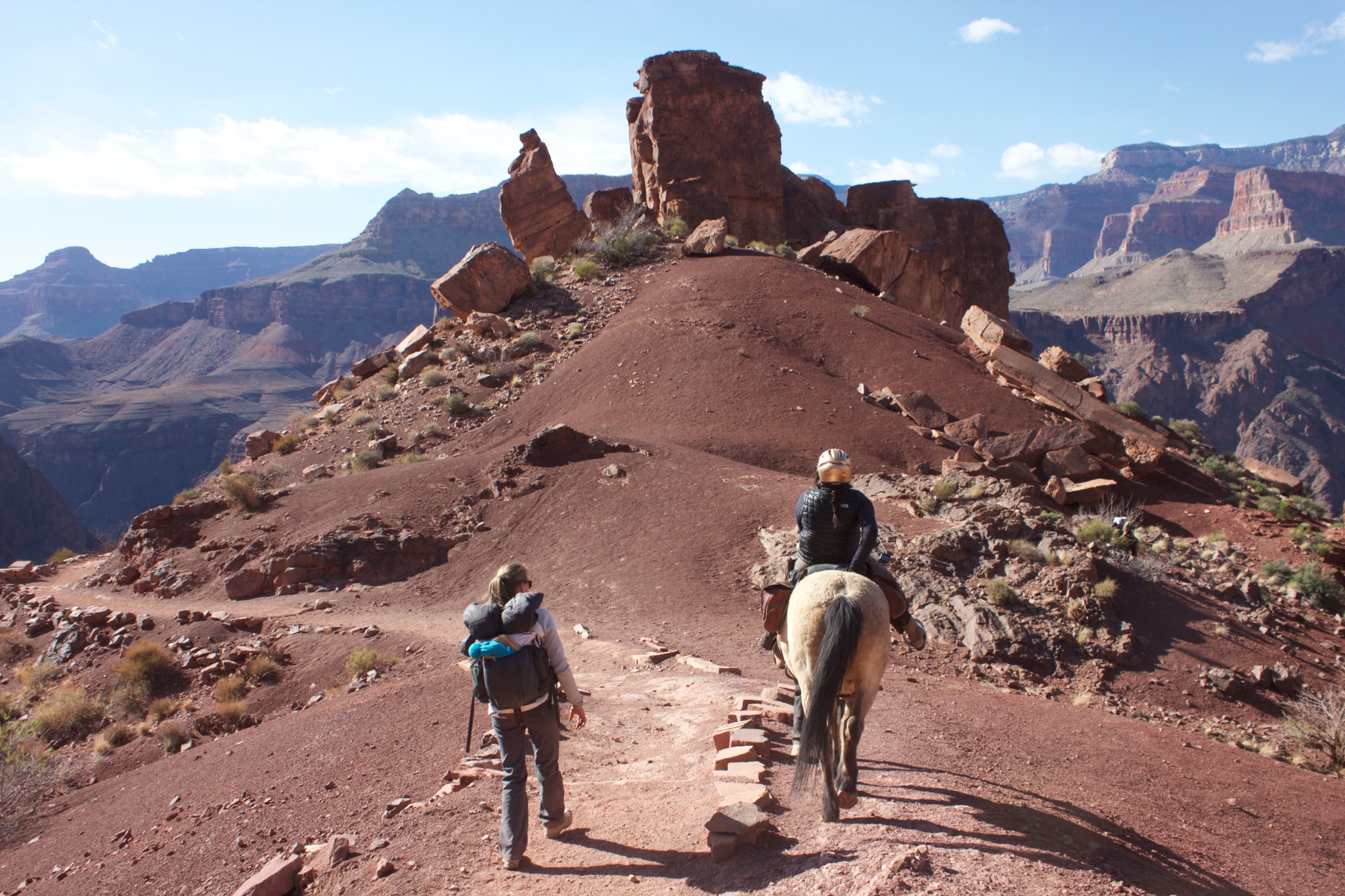 Cara Yar Khan riding a mule while an expedition teammate walks beside her on a Grand Canyon trail.